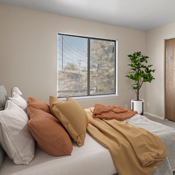 a bedroom with a bed with pillows and blankets on it