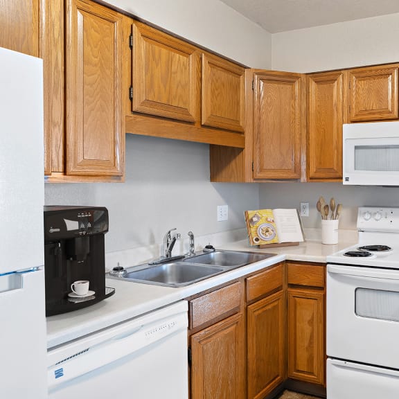 a kitchen with white appliances and wooden cabinets