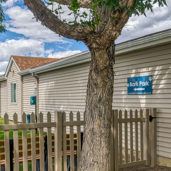 a row of houses with a fence and a tree
