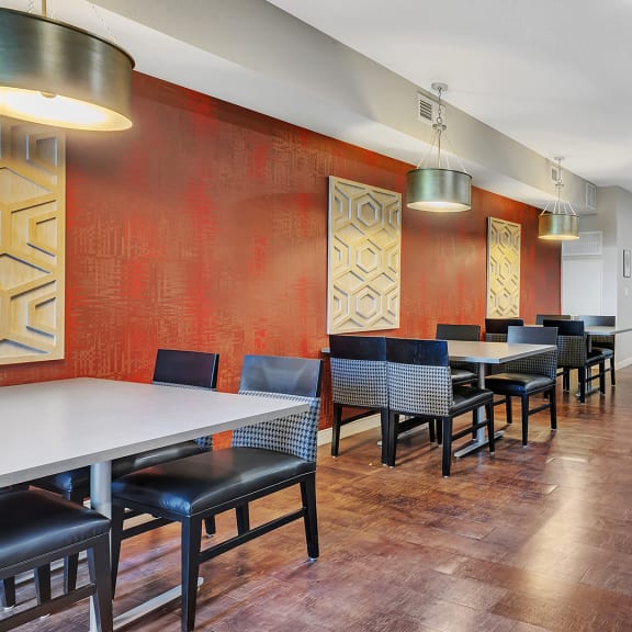a dining room with tables and chairs in front of a red wall
