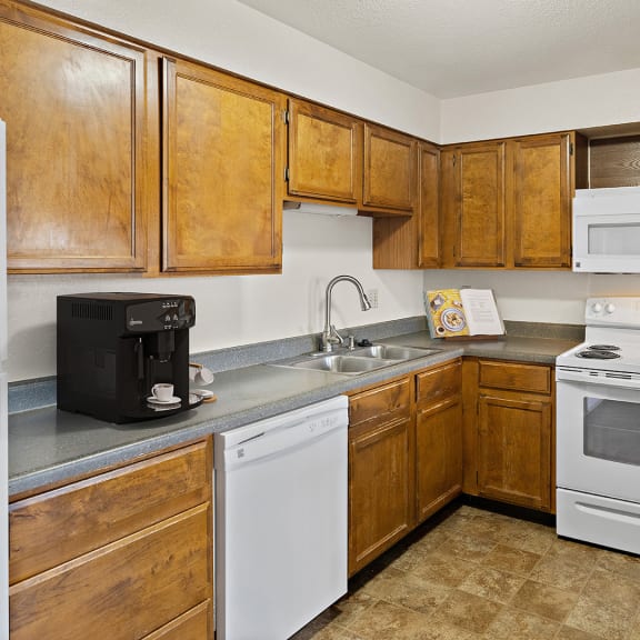 a kitchen with white appliances and wooden cabinets