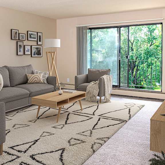 A living room with a grey couch, a grey chair, a wooden coffee table, and a large window with a view of trees.