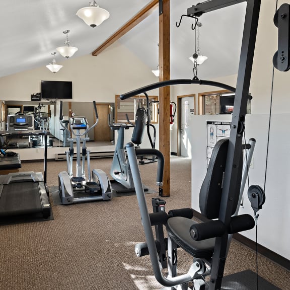 a gym with cardio machines and weights on the floor