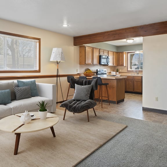 a living room and kitchen with a couch and a table