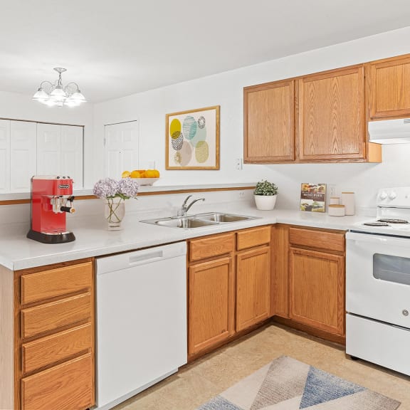 a kitchen with white appliances and wooden cabinets