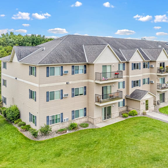 an aerial view of an apartment building with green grass and trees