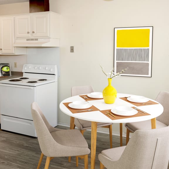 a kitchen with white appliances and a table with chairs