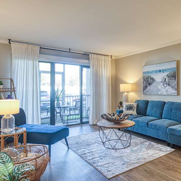 A living room with a blue sofa and a large window.