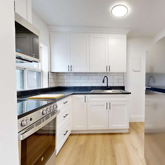 A kitchen with a table and chairs in the foreground and a refrigerator in the background.