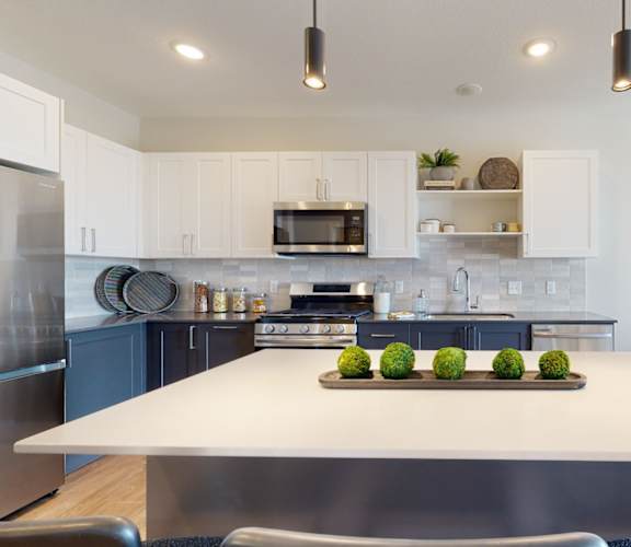 a kitchen with white cabinets and stainless steel appliances