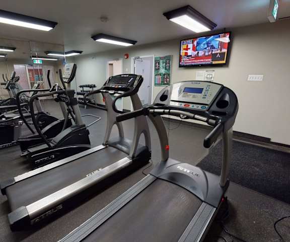 A gym with cardio and weight machines at Cambridge West Apartment Homes. 