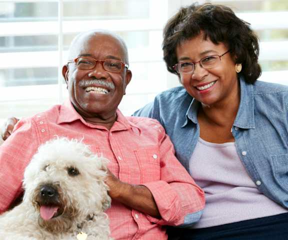 a man and a woman sitting on a couch with a dog at Briar Park 55+ Apartments, Atlanta