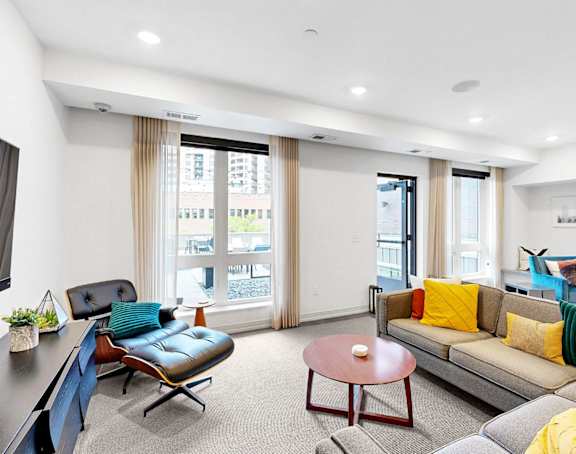 A living room with a blue couch and a yellow throw pillow.
