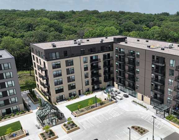 an aerial view of an apartment complex with trees in the background