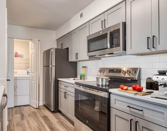 A modern kitchen with a refrigerator, oven, and microwave.
