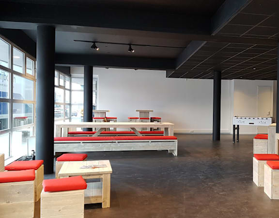 A room with a lot of furniture and a white wall.