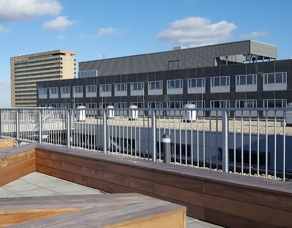 A modern building with a balcony and a bench.