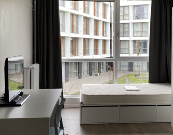 A modern room with a large window overlooking a building.