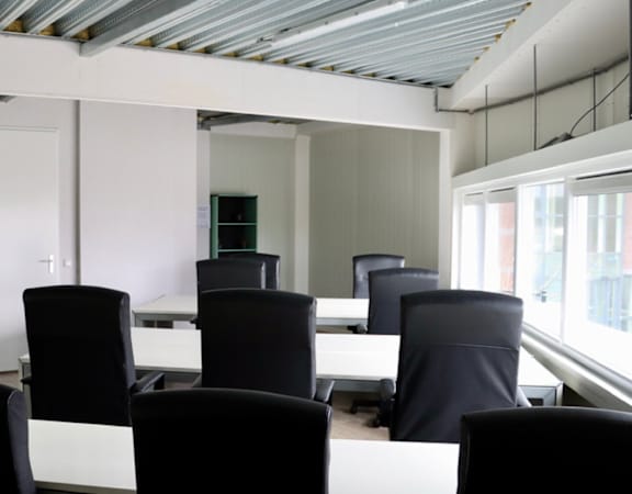 A conference room with black chairs and a white table.