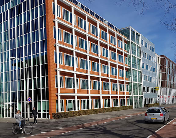 A modern building with orange and blue glass windows.