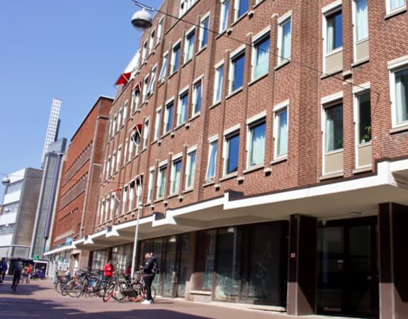 A red brick building with a white awning and a bicycle parked in front.