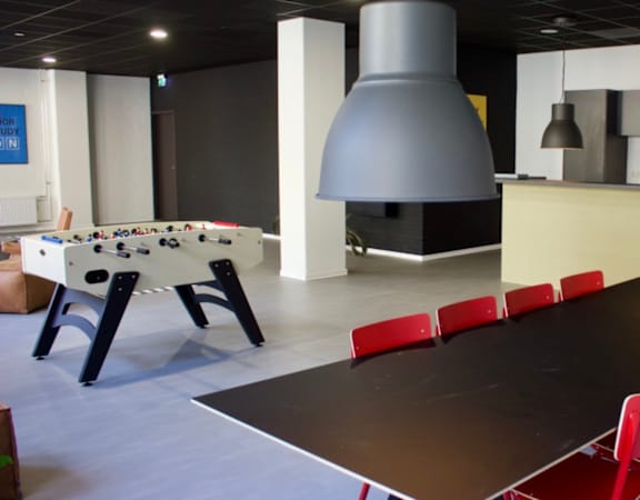 A room with a pool table, a bar, and a billiards table.