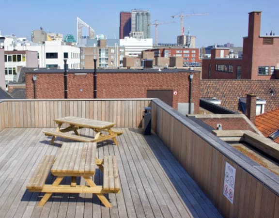 A wooden deck with two picnic tables on it.