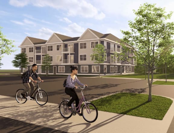 Two people riding bicycles in front of a large building.