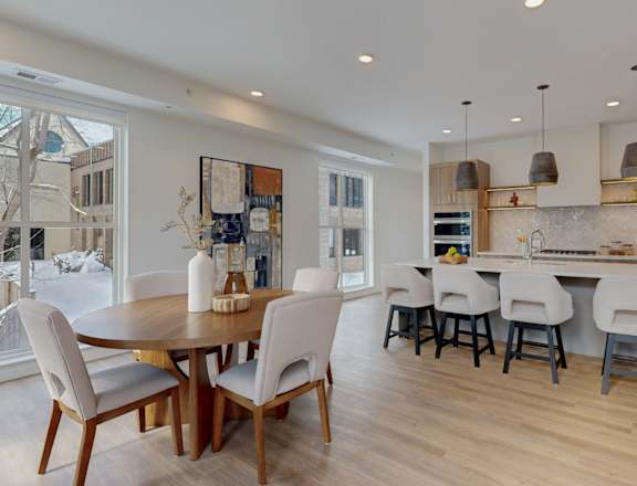 A modern kitchen with a dining table and chairs.