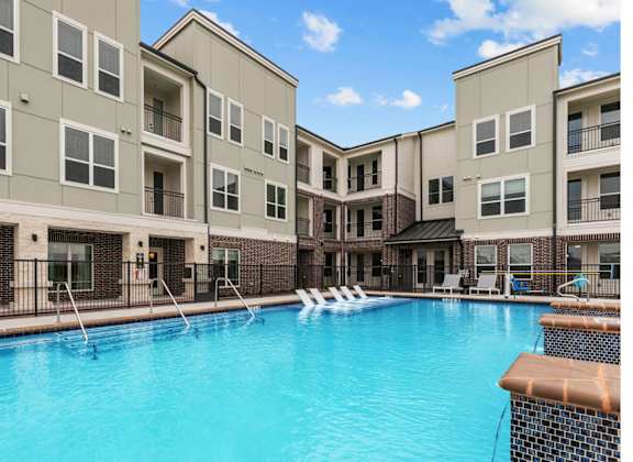A swimming pool in front of apartment buildings.