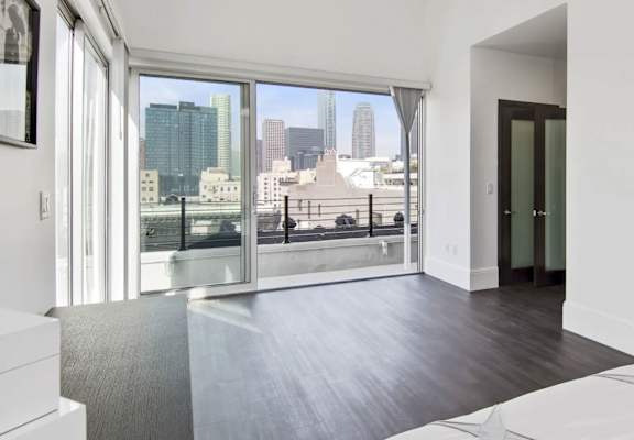 A spacious room with a view of the cityscape through the windows.