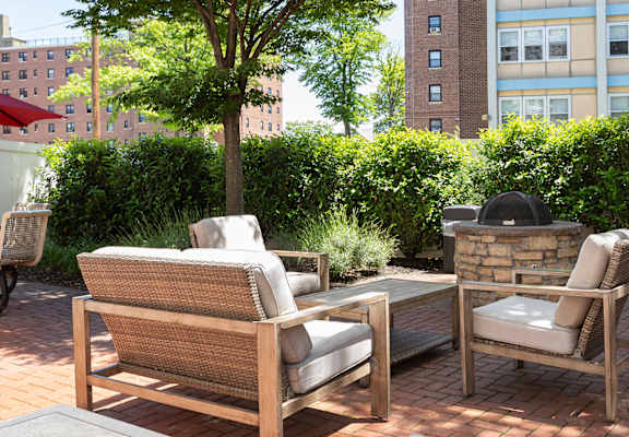 Two chairs and a sofa are on a patio.