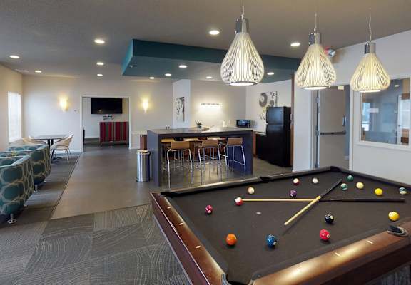 a game room with a pool table and a bar