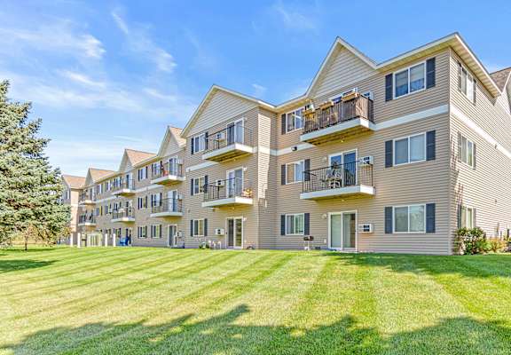 a large apartment building with balconies and a lawn
