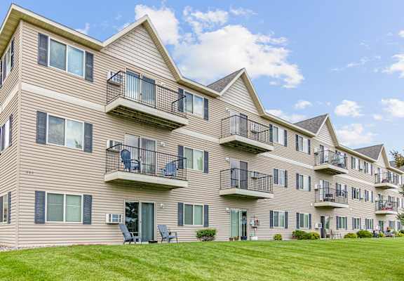 the view of an apartment building with balconies and a lawn