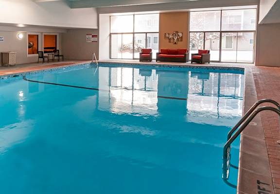 a large indoor pool with chairs and a couch next to it