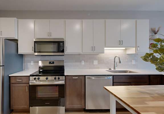 A modern kitchen with stainless steel appliances and white cabinets.
