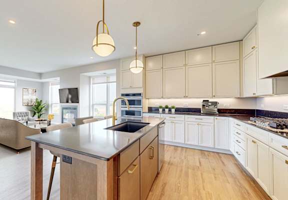 A modern kitchen with a large island and wooden cabinets. at Ardor on the Bluffs South Loop Residences Apartments, Bloomington, 55425