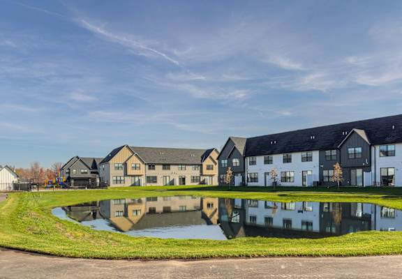 a pond in front of a row of houses