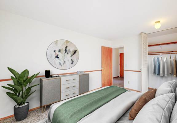A bedroom with a bed, a couch, and a wardrobe.