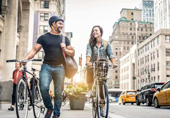 A man and a woman are riding bicycles on a city street.