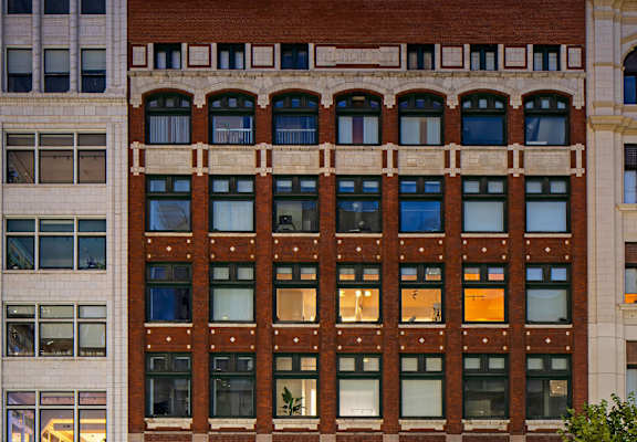 A large red brick building with many windows in between.