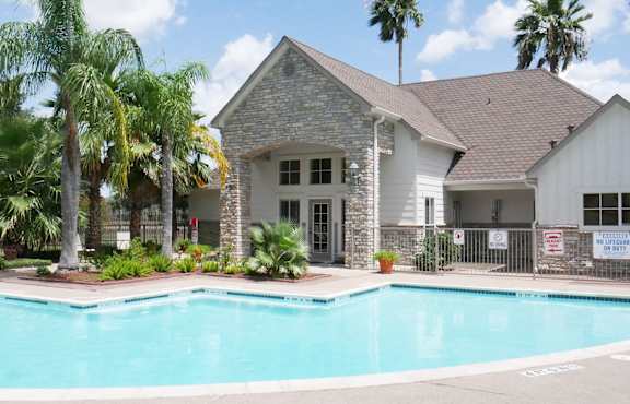 A house with a pool in front of it.