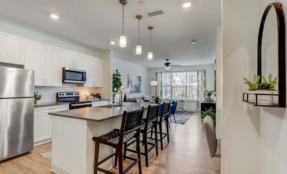 A modern kitchen with a large island and bar stools.