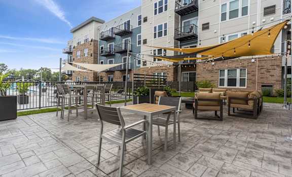 A patio with a table and chairs is surrounded by a fence and buildings.