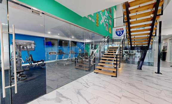 A gym with a staircase and a glass wall.
