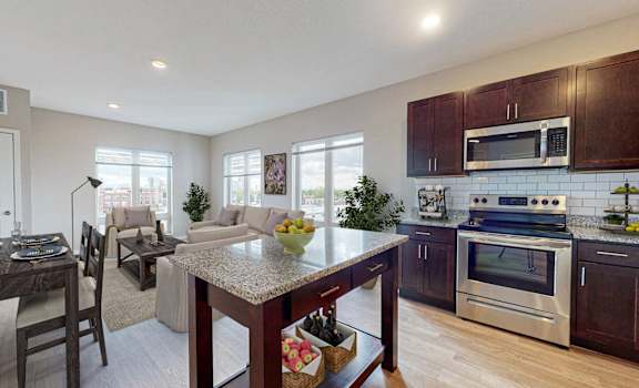 A modern kitchen with dark wood cabinets and stainless steel appliances.
