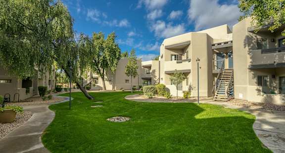 an apartment building with green grass and trees