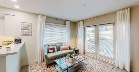 a living room with a couch and a glass coffee table  at Chase Knolls in Sherman Oaks, CA 91423