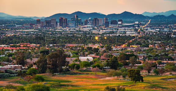 A cityscape with buildings and greenery in the foreground.at Sahuaro West Apartments, Phoenix Arizona
